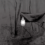 Steel target heater in use: thermal view of a heated steel silhouette glowing white among trees
