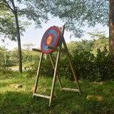 Traditional straw target on a wooden stand outdoors under trees — image 6