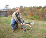 Man seated on the Clay Hawk trap seat loading a clay outdoors — image 2