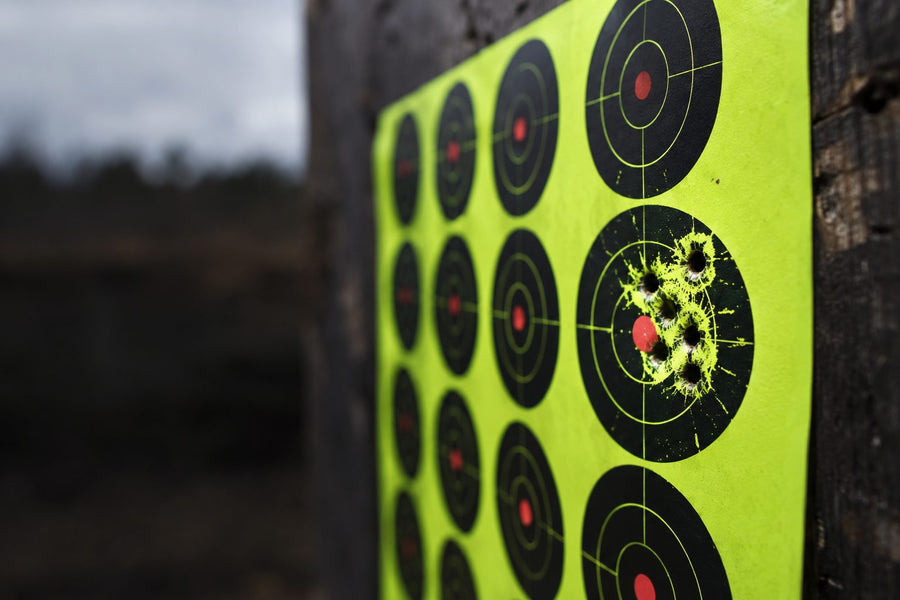 Close-up of a fluorescent splatter target with a tight group of hits, each ringed by a bright yellow halo